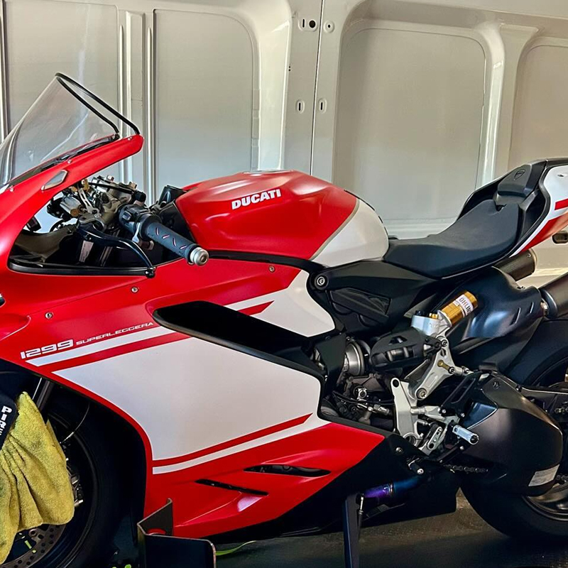 Red and white Ducati sports bike loaded inside a van