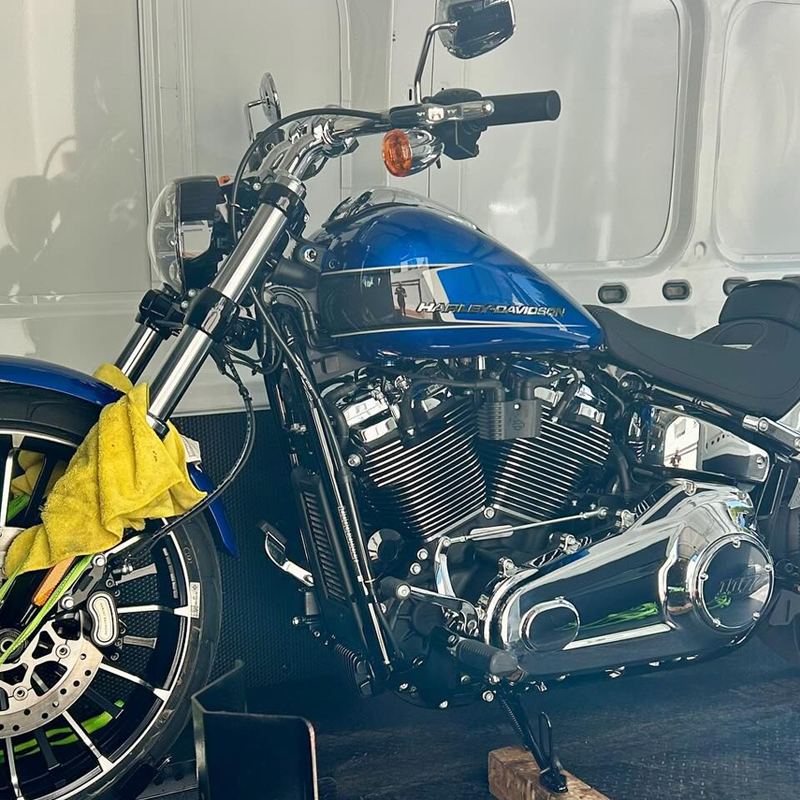Blue and chrome Harley-Davidson motorcycle strapped inside a van