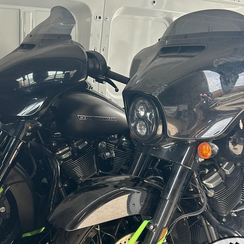 Two black touring motorcycles with fairings side by side in a van