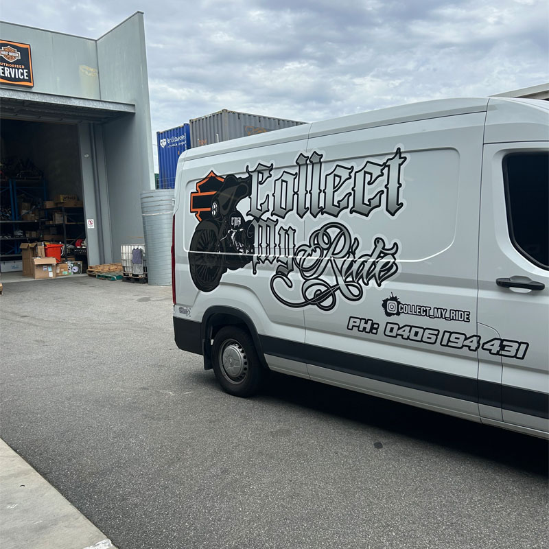 Branded white transport van parked outside a workshop roller door
